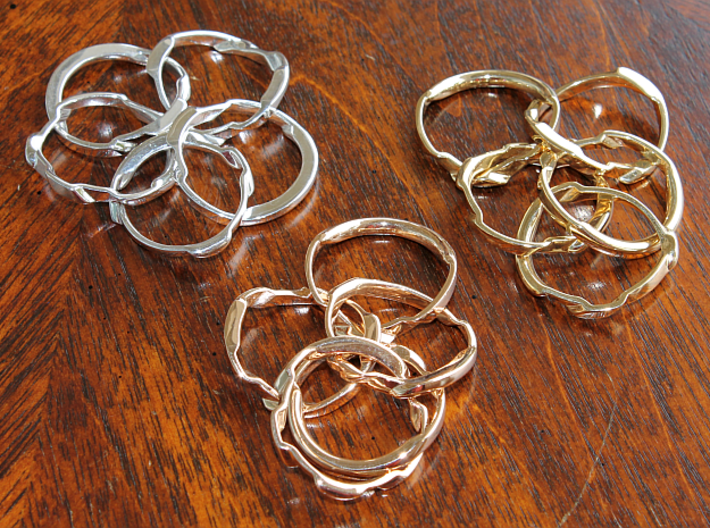 WOW5 Puzzle Ring 3d printed Interlocking Silver, Bronze, and Brass in the scrambled state.