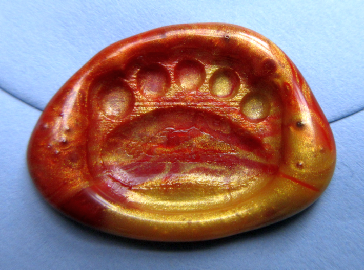 Teddy-bear paw wax seal 3d printed Close-up of a seal in a mixture of brown and gold wax