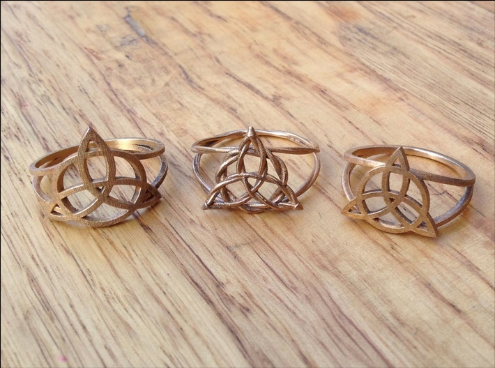 Woven triquetra (choose size) 3d printed The three Kickin' Wiccan styles of triquetra ring, side-by-side so you can compare. All three are in raw bronze. The woven style costs more, because it takes me longer to adjust the band for individual ring sizes. 