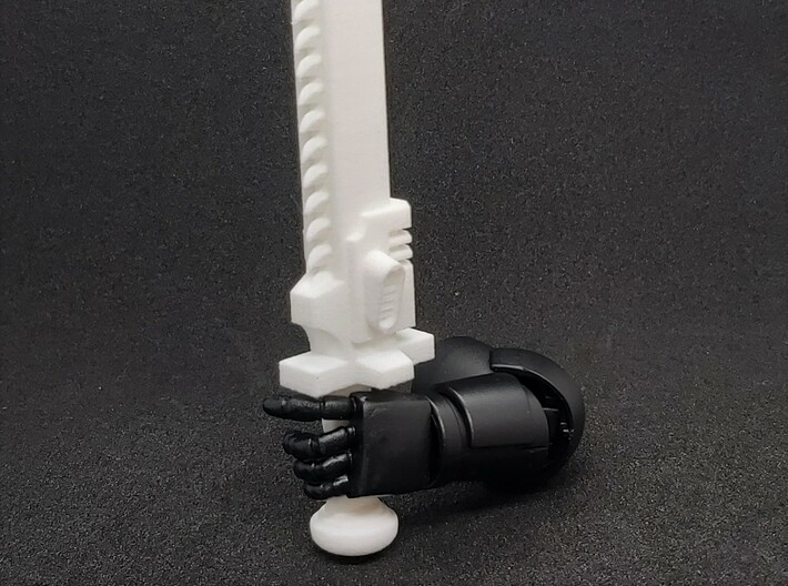 Action Figure Chainsword - Right Handed 3d printed Printed in White Natural Versatile Plastic, held by the hand of a 1:12 scale action figure arm, Left Handed version shown