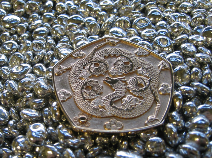 Polished Dragon Coin 3d printed oblique glamour shot - on a bed of shiny pebbles
